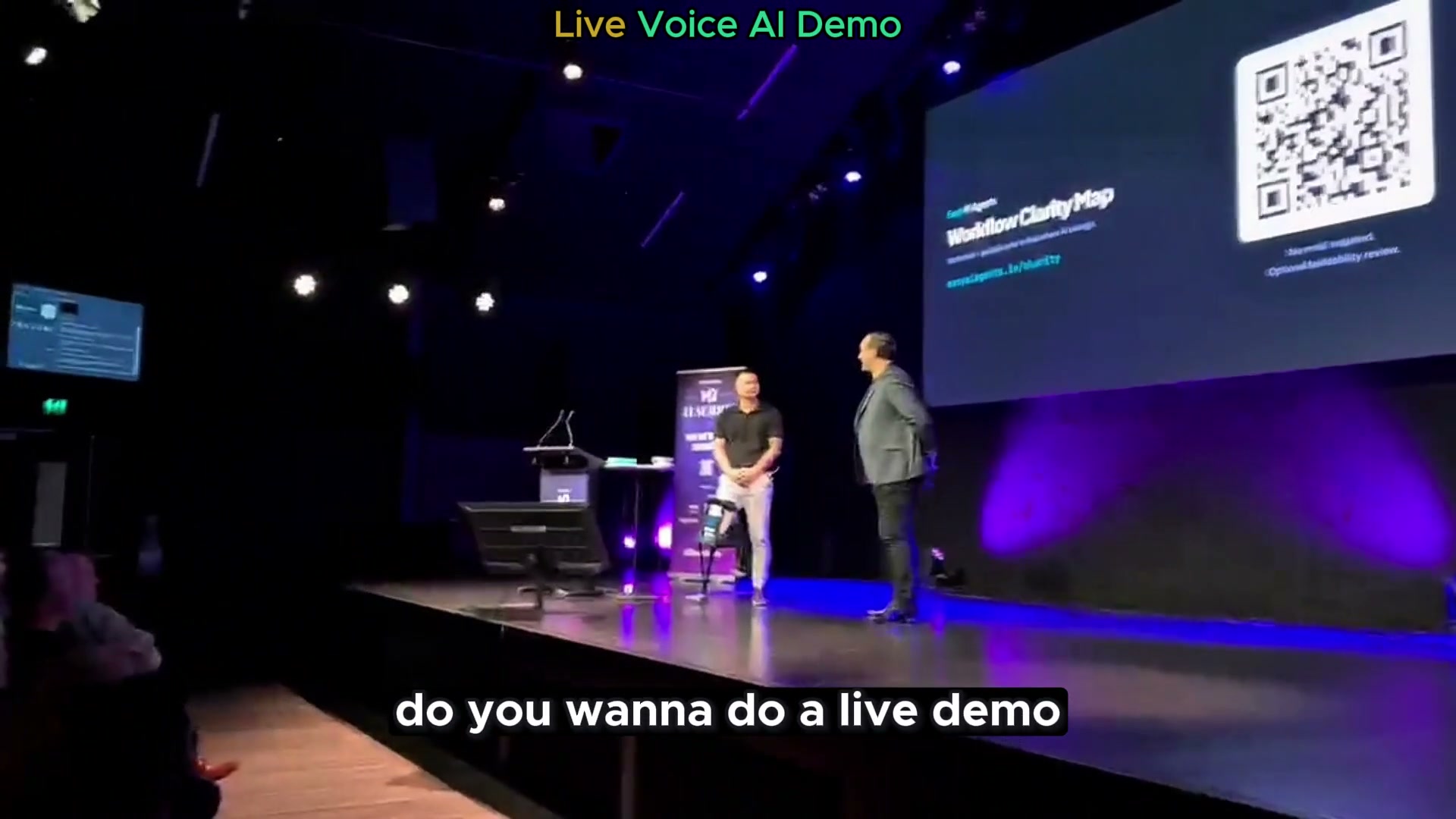 Owen on stage at the M2 AI Summit running a live voice AI booking demo